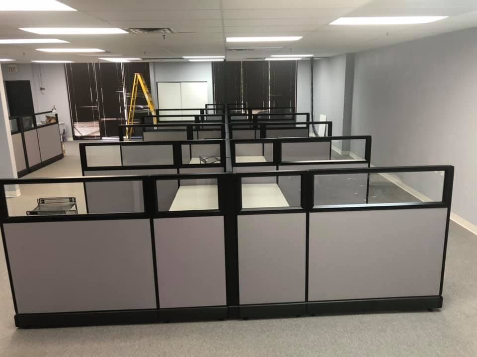 Cubicles with glass-topped panels assembled in an open office during an Eggleston Office install, a ladder still on site