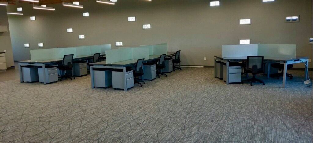 Benching workstations with frosted privacy screens and mobile pedestals on an open office floor